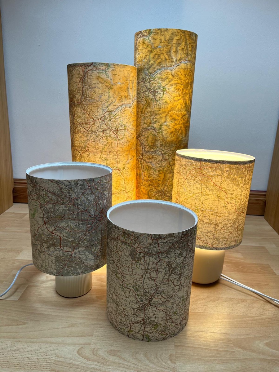 Vintage map lampshades in various sizes, glowing warm light