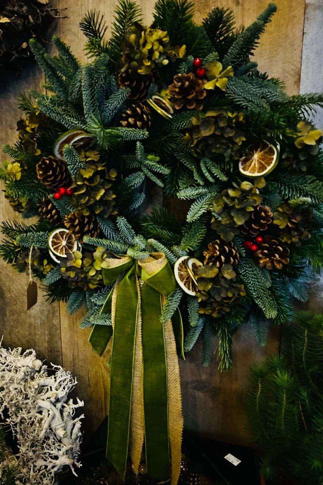 Christmas wreath with pine cones, dried oranges and green velvet ribbon